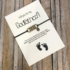 Godfather bracelet with customized initial charm, placed on "Will you be my godfather" proposal card